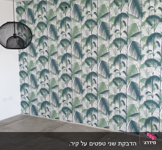 הדבקת טפט מעוצב בדוגמת עלי דקל ירוקים על קיר בסלון